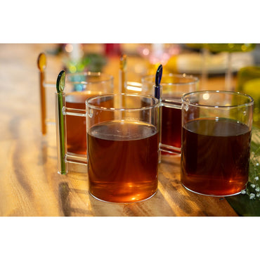 Glass cups with amber liquid on a wooden surface