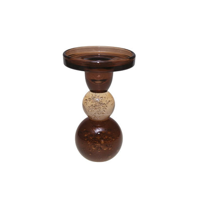 Decorative glass candle holder with three spherical sections on a white background