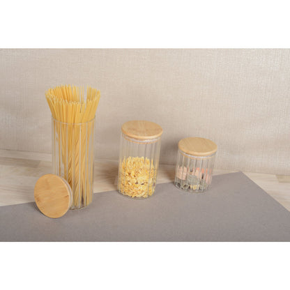 Clear jars with wooden lids containing different types of pasta on a neutral background cosy vibes